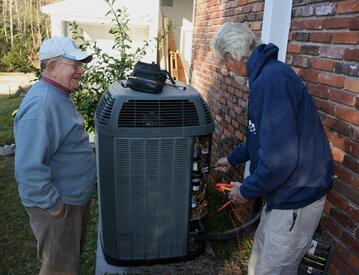 older-male-customer-talking-with-hvac-service-technician