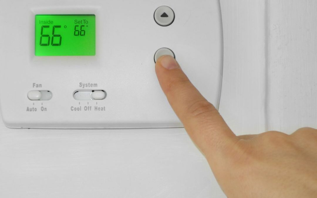 person-adjusting-temperature-on-thermostat