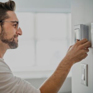 man-with-glasses-changing-thermostat