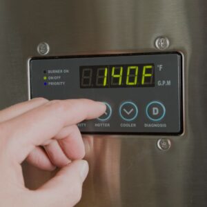 person-adjusting-the-temperature-on-a-water-heater