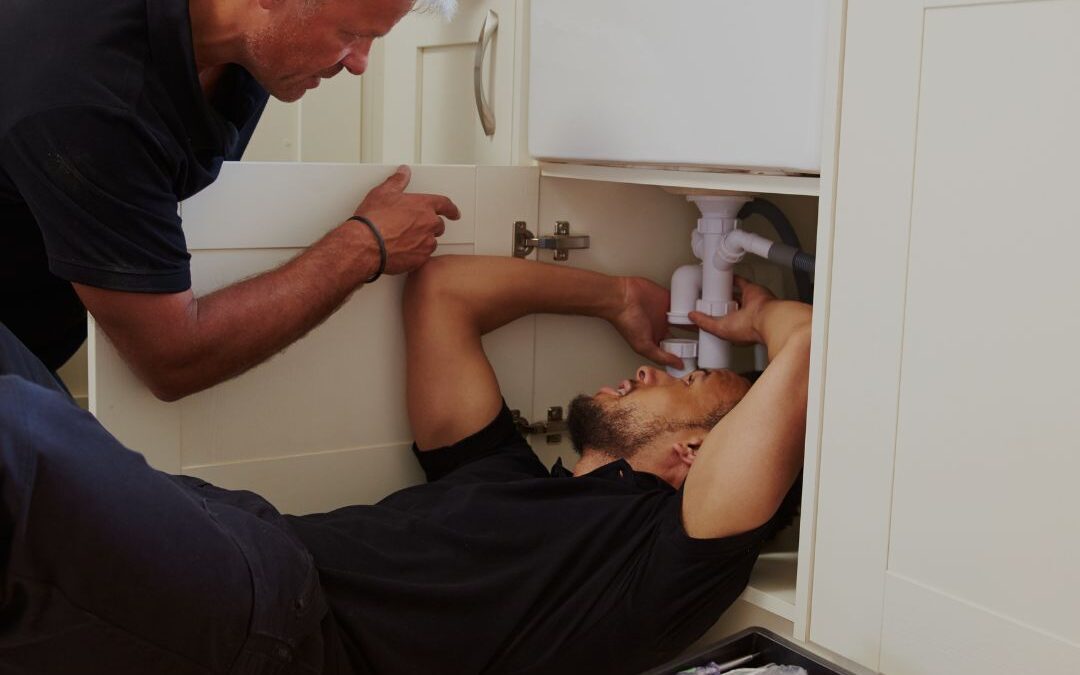 plumbers-working-under-kitchen-sink