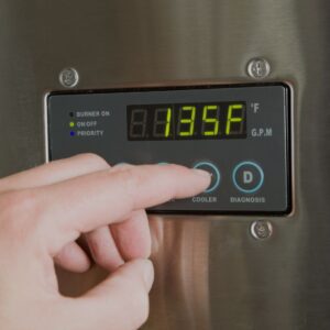 person-adjusting-temperature-on-a-water-heater