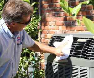 Heating-and-Air-Tech-Wiping-Down-HVAC-System