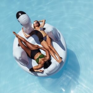 Two-Middle-Aged-Girls-Laying-Out-on-Big-Pool-Float